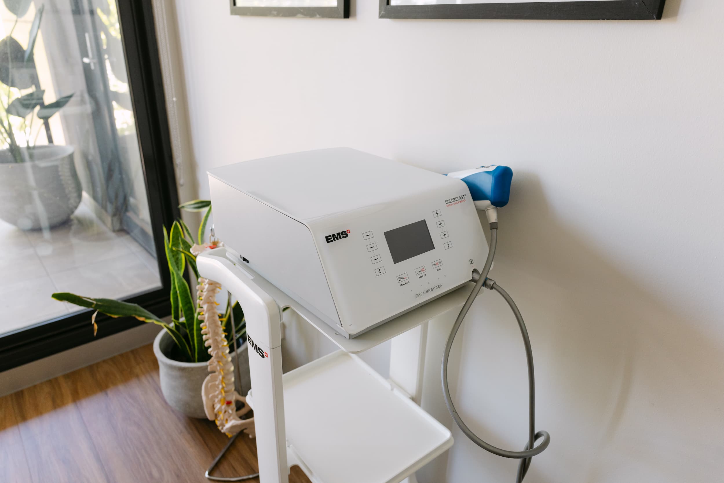 EMS shockwave therapy device in clinic room, ready for radial and focused treatment.