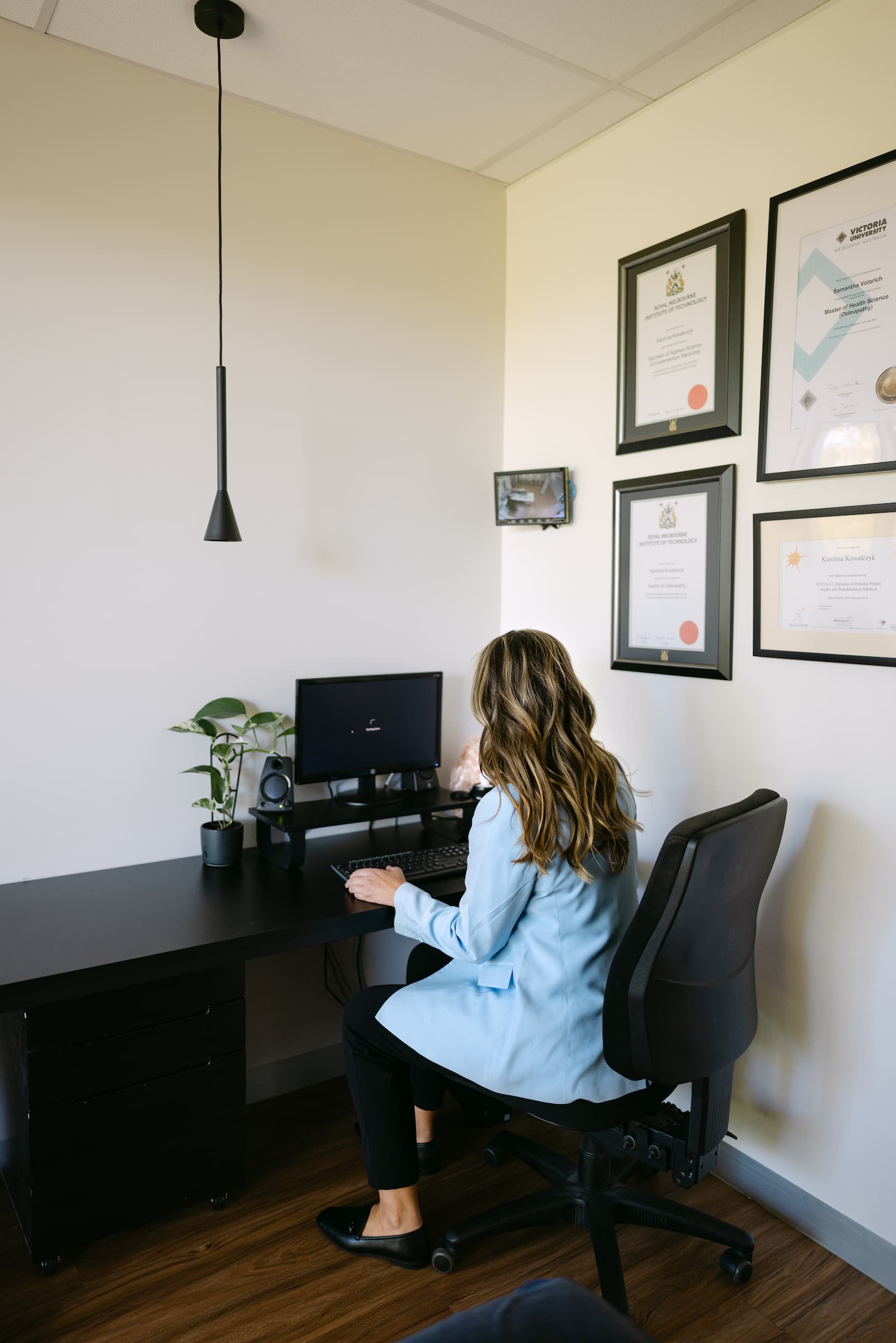 Live Well clinician preparing GP referral notes at desk in private consultation room.