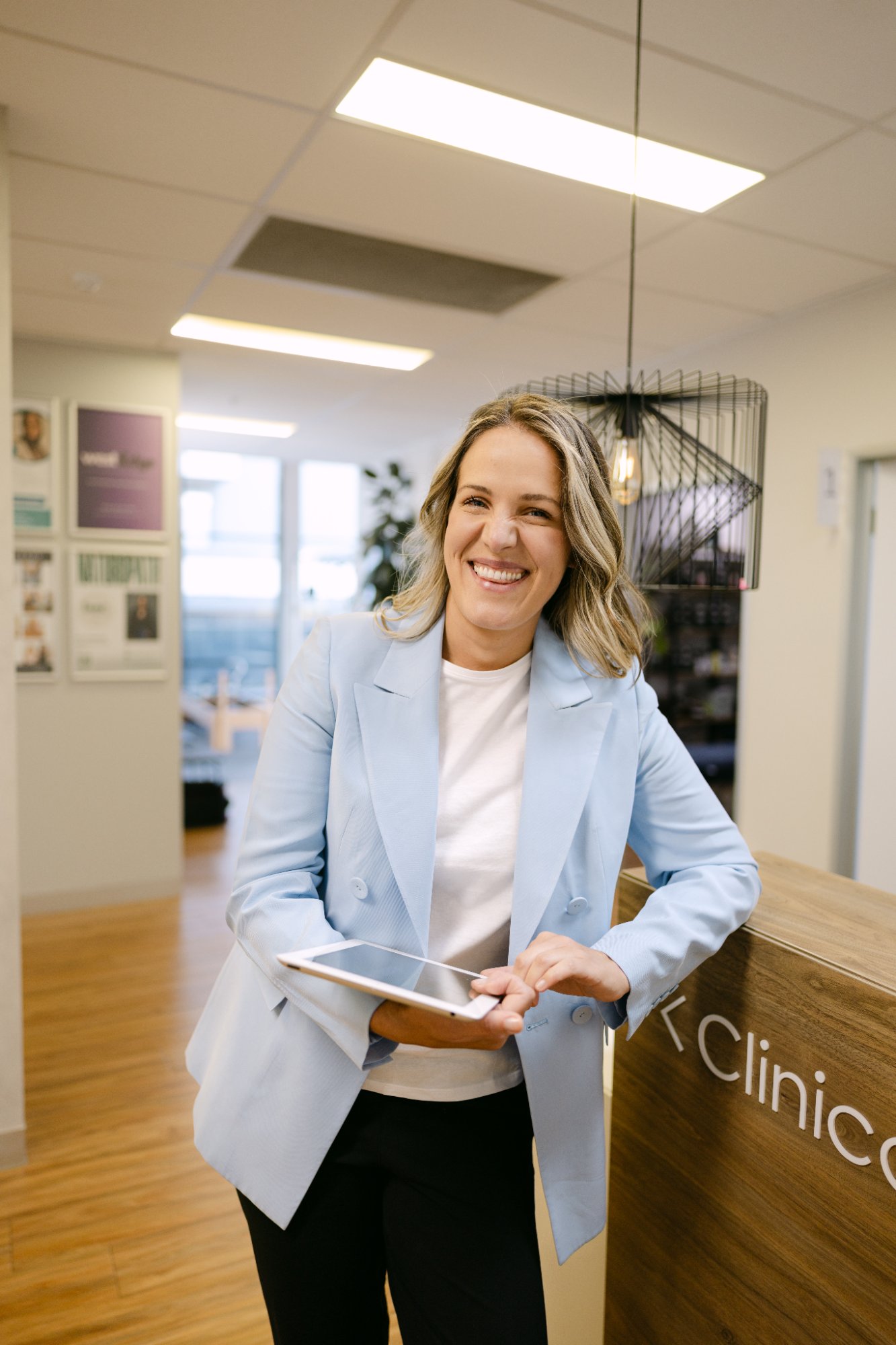 Karolina Kowalczyk, Director of Live Well Health Centre, smiling at clinic reception desk