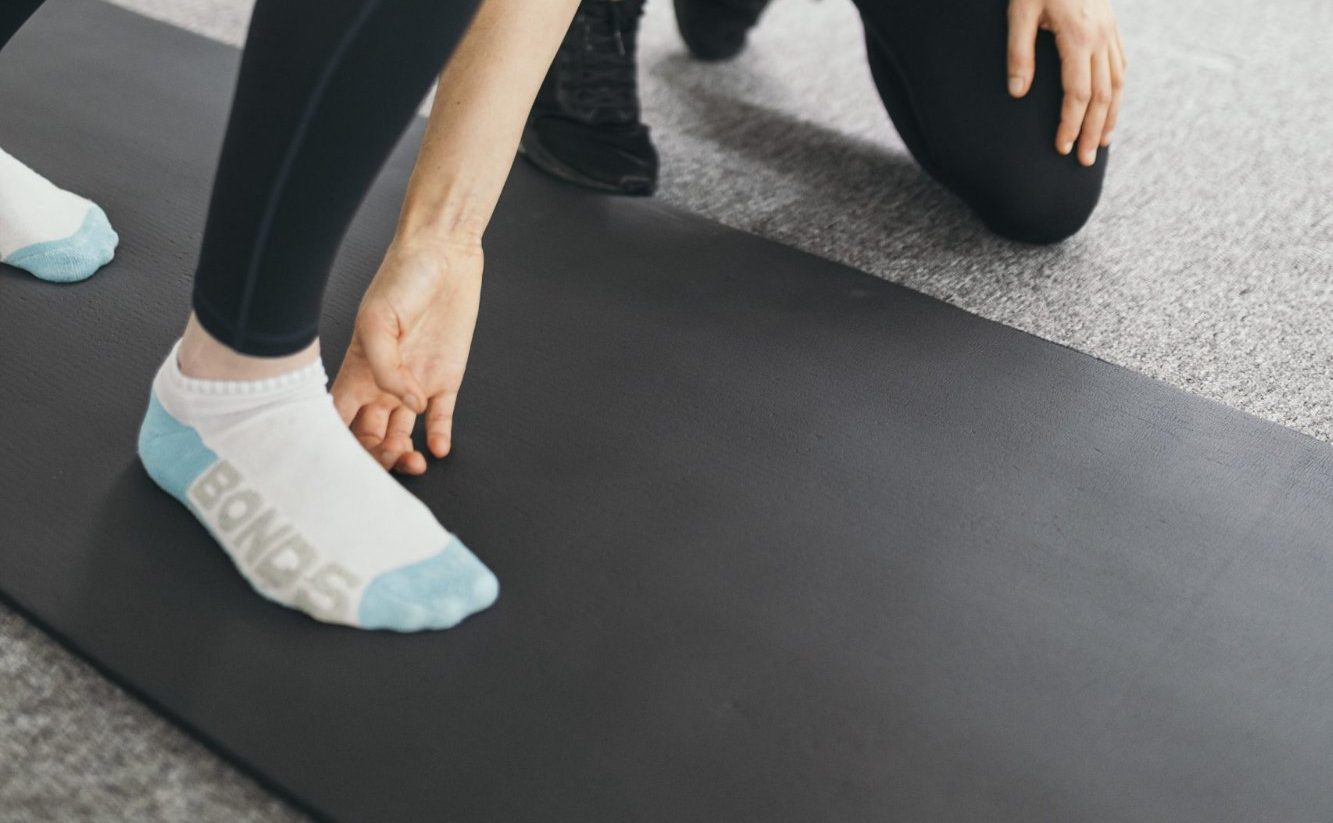 Live Well practitioner assessing patient's foot posture and alignment during gait analysis