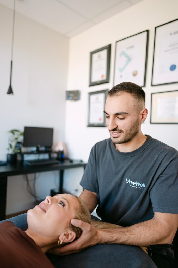 Live Well osteopath applying gentle cervical mobilisation to patient lying on treatment table