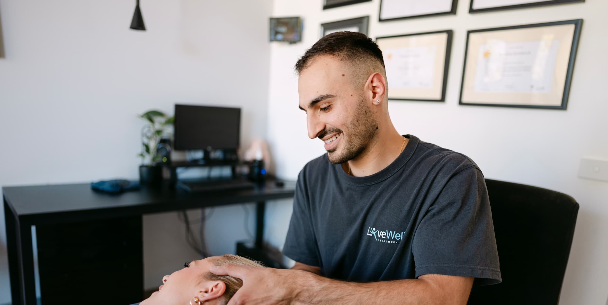 Live Well osteopath performing hands-on neck pain treatment on patient in clinic room