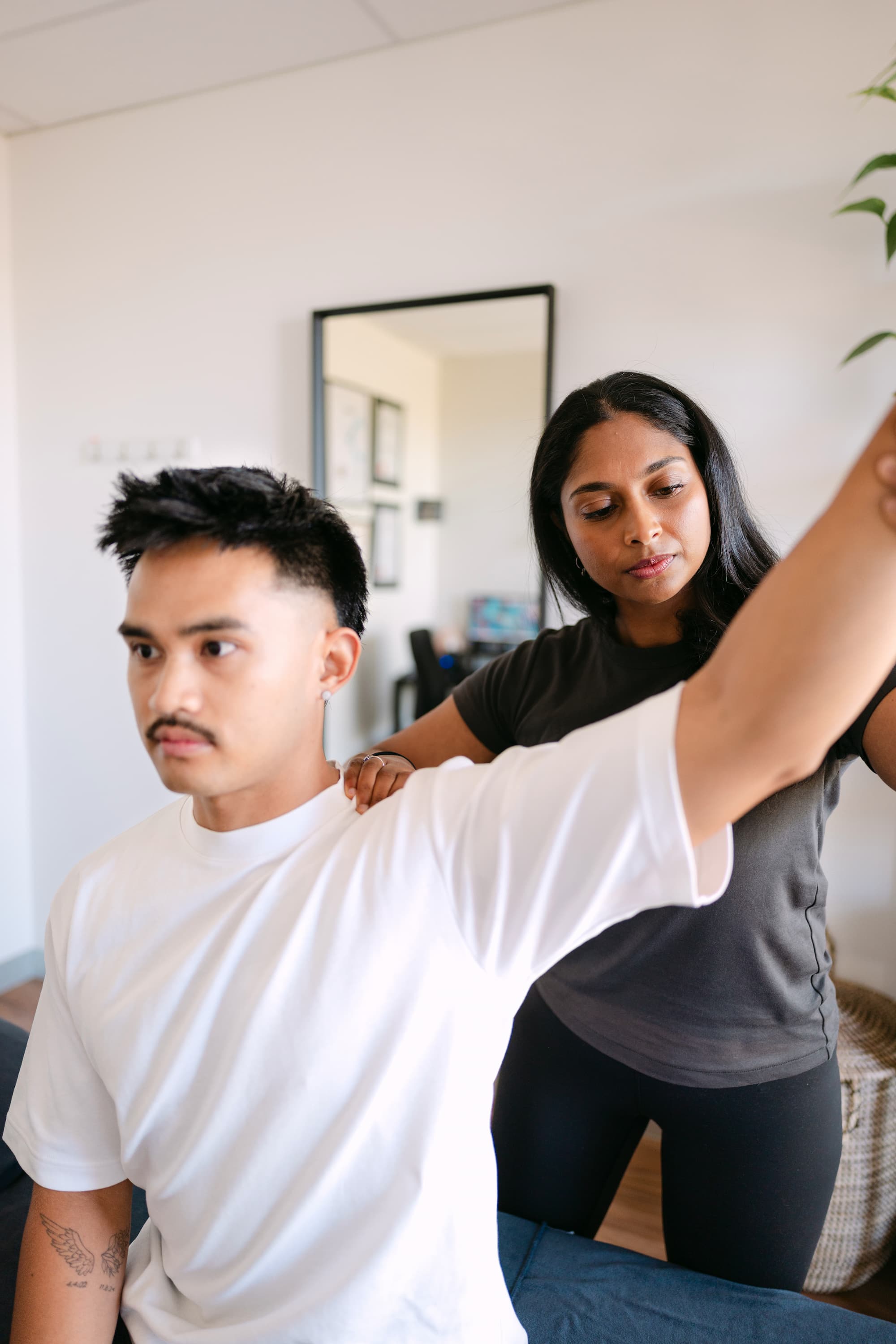 Live Well practitioner assessing patient shoulder mobility and range of motion in clinic