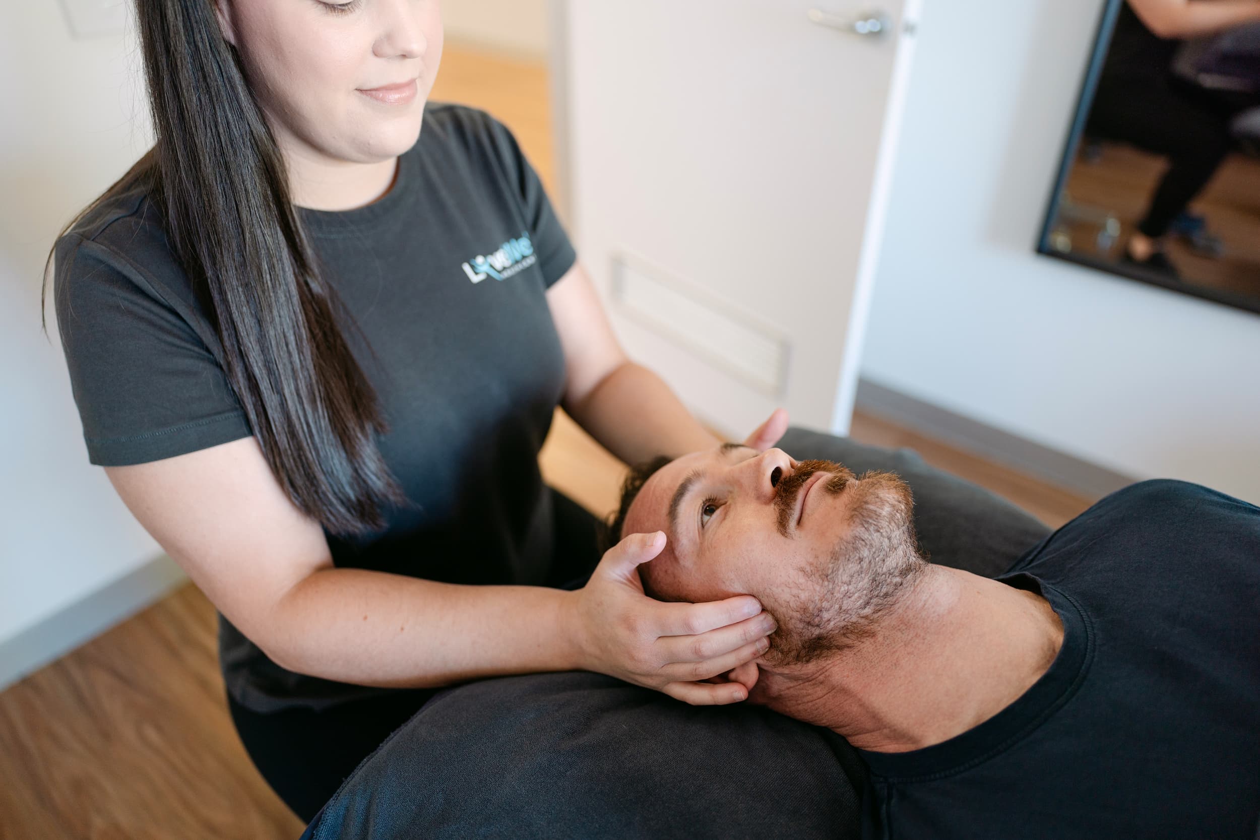 Live Well osteopath performing cervical and jaw mobilisation on patient for TMJ pain relief