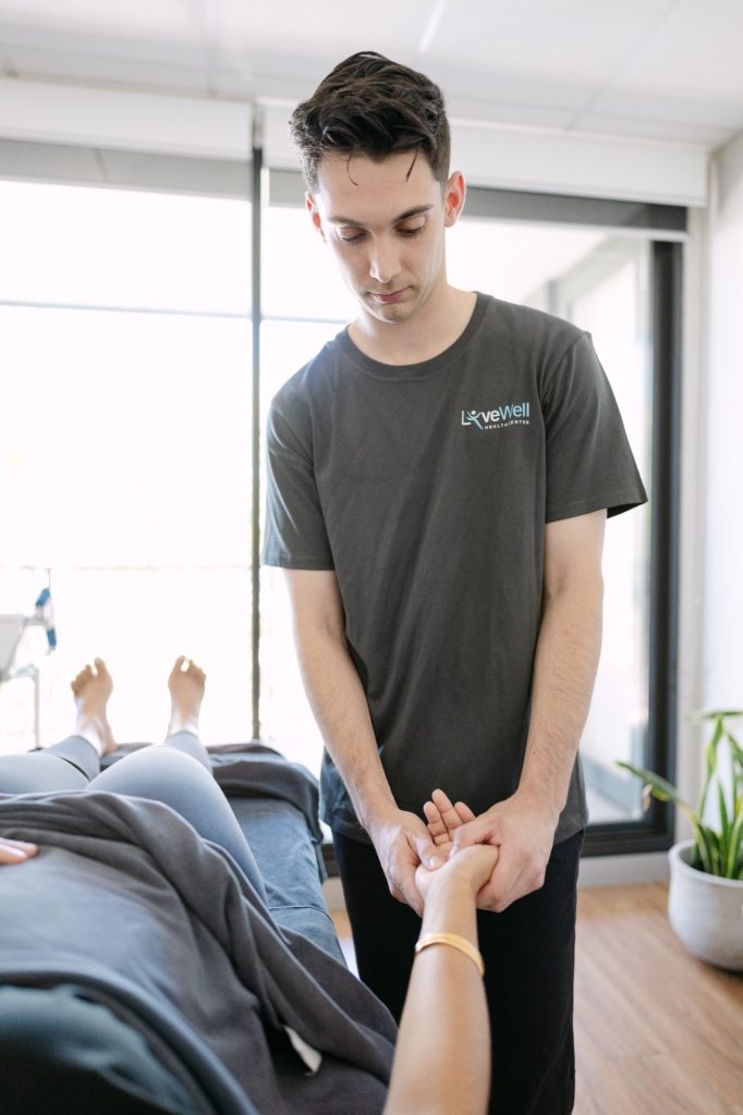 Live Well osteopath performing gentle wrist and hand mobilisation on patient for carpal tunnel relief