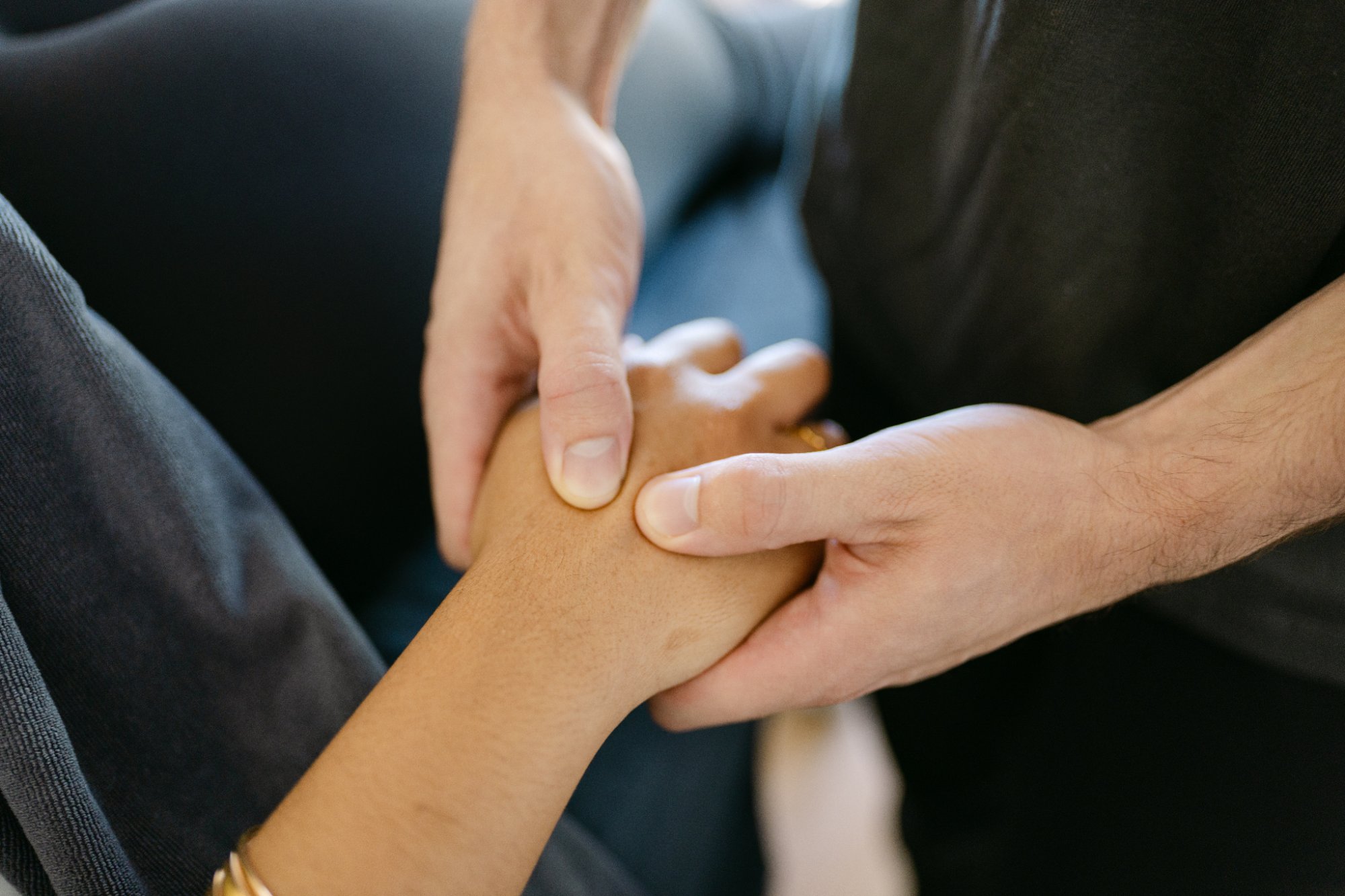 Close-up of Live Well practitioner performing hands-on wrist assessment for carpal tunnel syndrome