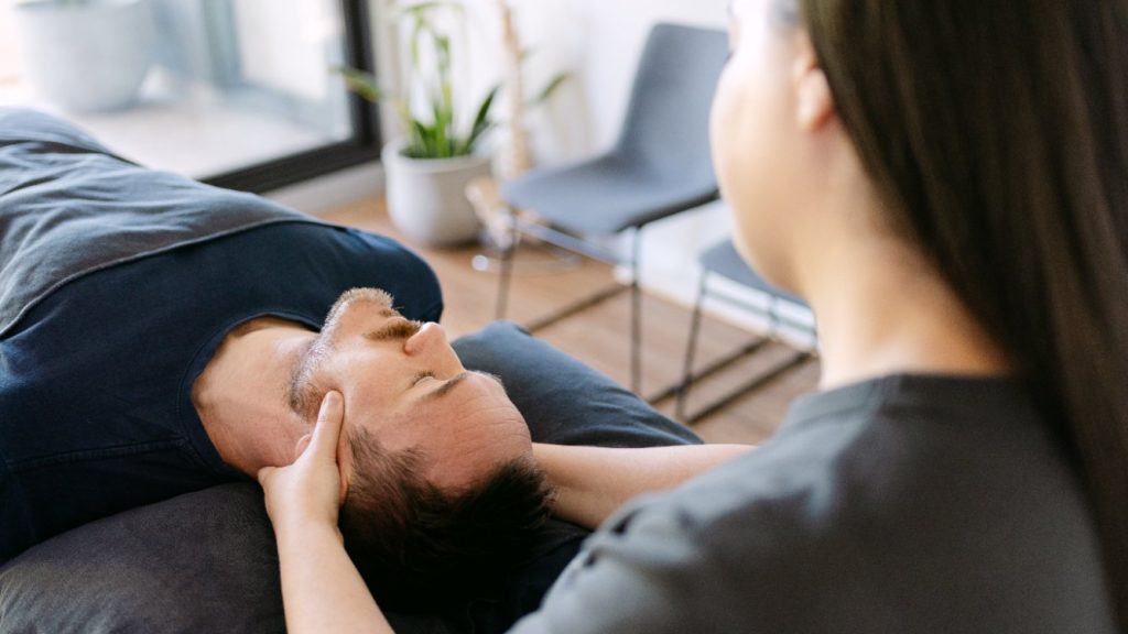 Dr Samantha Volarich performing suboccipital release on patient lying on treatment table for headache relief