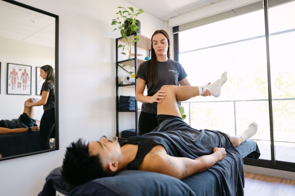 Live Well practitioner performing straight leg raise assessment on patient for sciatica diagnosis