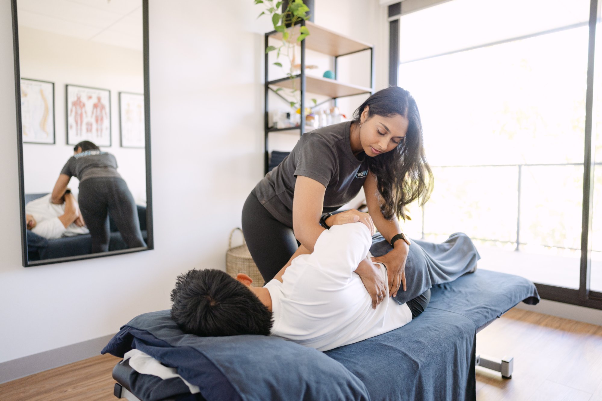 Live Well practitioner applying hands-on thoracic spinal mobilisation to patient for thoracic outlet syndrome relief