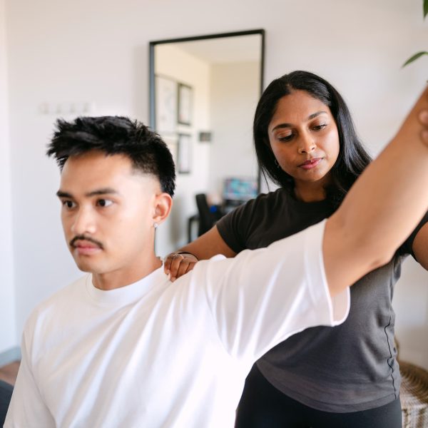 Live Well practitioner assessing patient shoulder mobility and range of motion in clinic